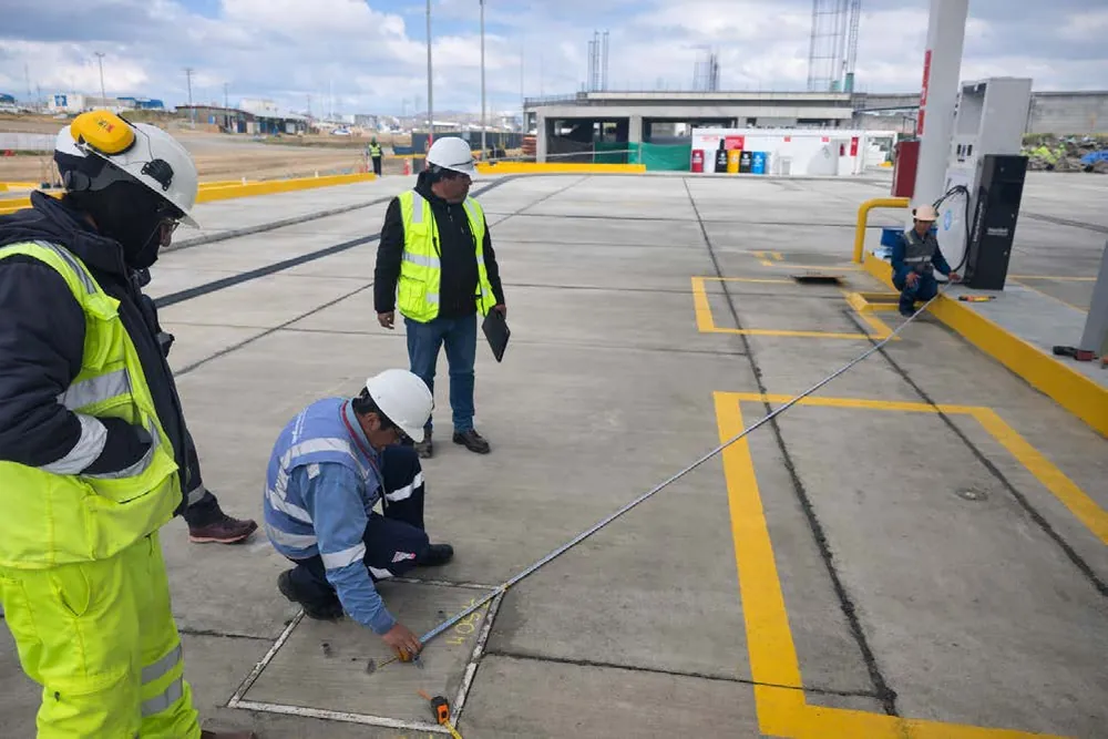 Técnicos midiendo áreas en el patio de maniobras